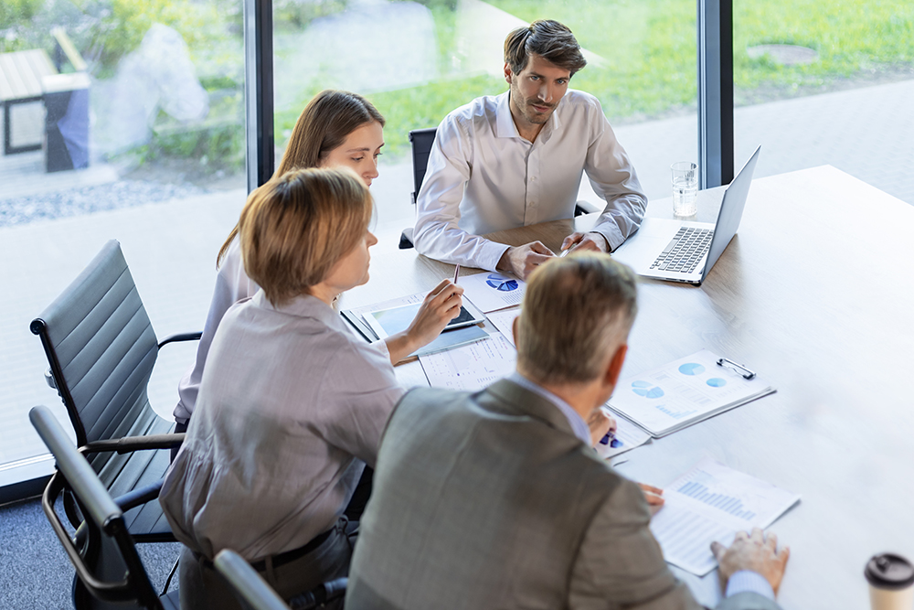 four-business-professionals-using-laptop-desk-discussing-strategy-company four-business-professionals-using-laptop-desk-discussing-strategy-company
